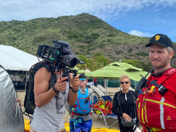 Kayak guide Santiago Stabile, ringed by a production team, talking to Seabourn Venture guests ahead of an excursion in St. Kitts. Photo Credit: Andrea Zelinski