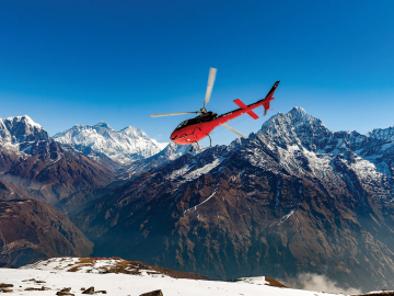 helicopter flying on top of a mountain