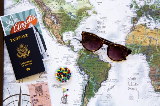World map with passport and sunglasses