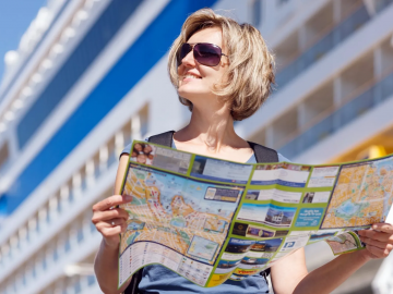 woman reading a map in front of a cruise ship