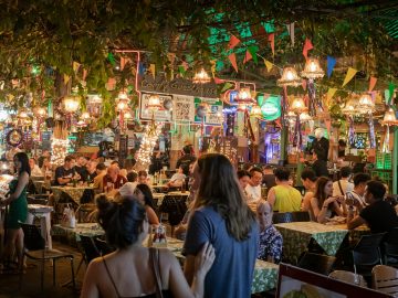 People in an open air restaurant at night time